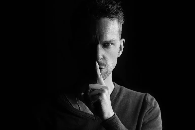 Farmacêutico fazendo sinal de silêncio com o dedo nos lábios, representando o sigilo profissional